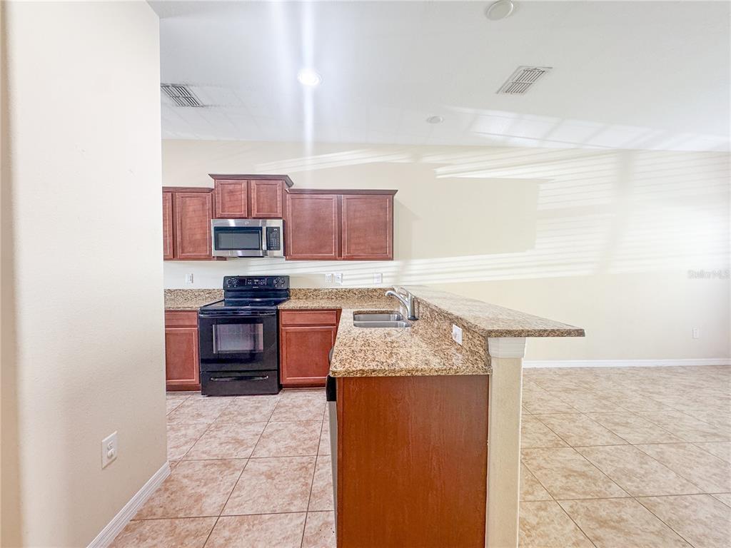 8542 Gablebend Way, Unit 8542 Tampa, FL 33647 - Photo 4 of 14 a kitchen with stainless steel appliances granite countertop a stove a sink and a microwave