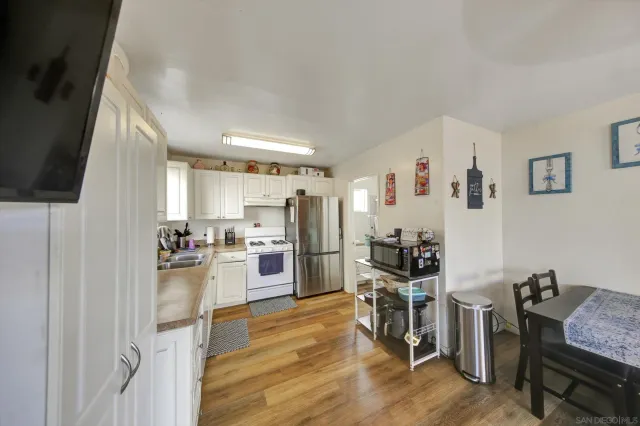 a kitchen with a refrigerator cabinets and wooden floor