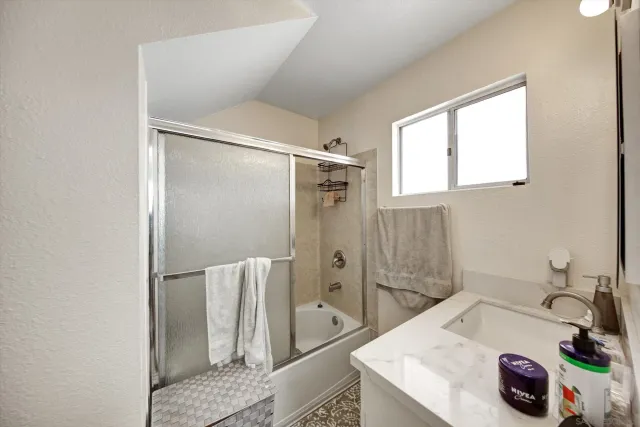 a bedroom with a bed tv and a window