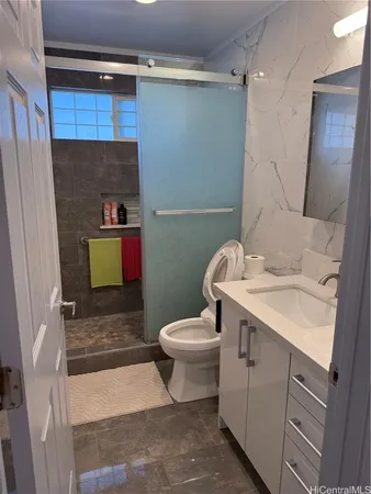 a bathroom with a sink a toilet and shower