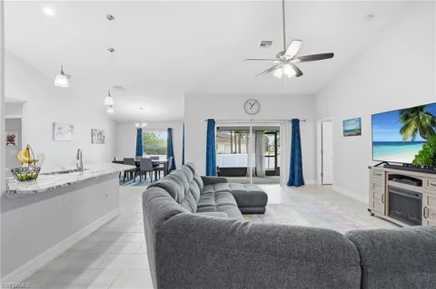 a living room with furniture a chandelier and a flat screen tv