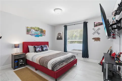 a bedroom with a bed and a dresser next to a window