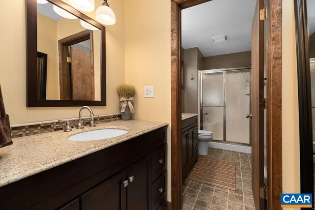 a bathroom with a granite countertop sink toilet and shower