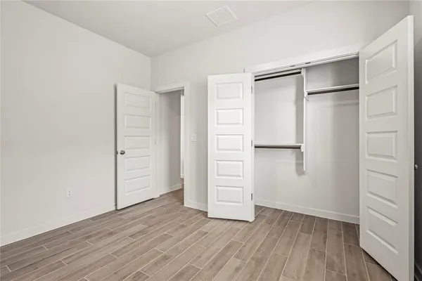 an empty room with closet and wooden floor