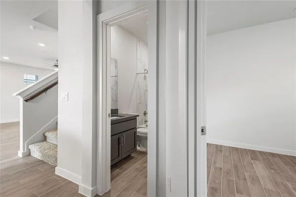 a view of a hallway with wooden floor and entryway