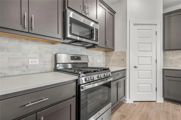 a kitchen with stainless steel appliances a stove microwave and cabinets