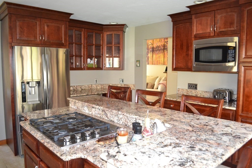 38 Lincoln Point Road Charlton, MA 01507 - Photo 7 of 25 a kitchen with stainless steel appliances granite countertop a stove top oven a sink a dining table and chairs
