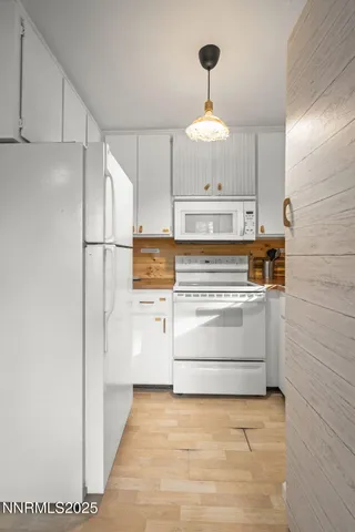 a view of kitchen with wooden floor and electronic appliances