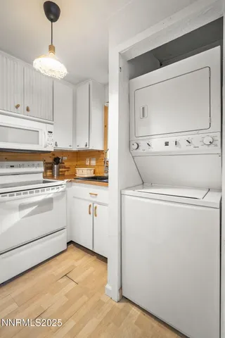 a kitchen with a refrigerator and white cabinets