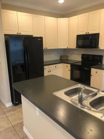 a kitchen with stainless steel appliances a stove a microwave a sink and a refrigerator with wooden cabinets