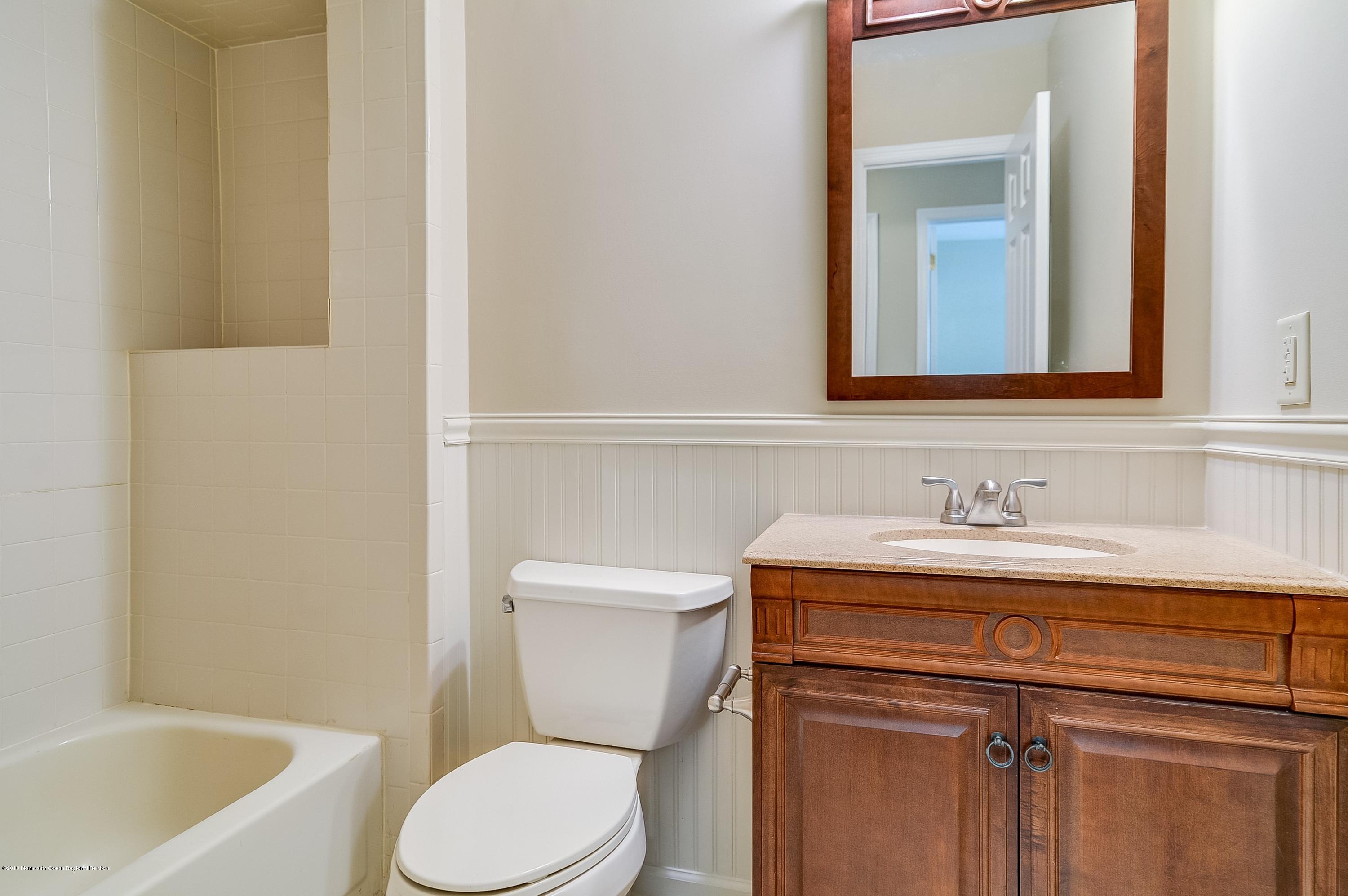 41 Apple Drive Spring Lake Heights, NJ 07762 - Photo 20 of 32 a bathroom with a granite countertop toilet sink and mirror