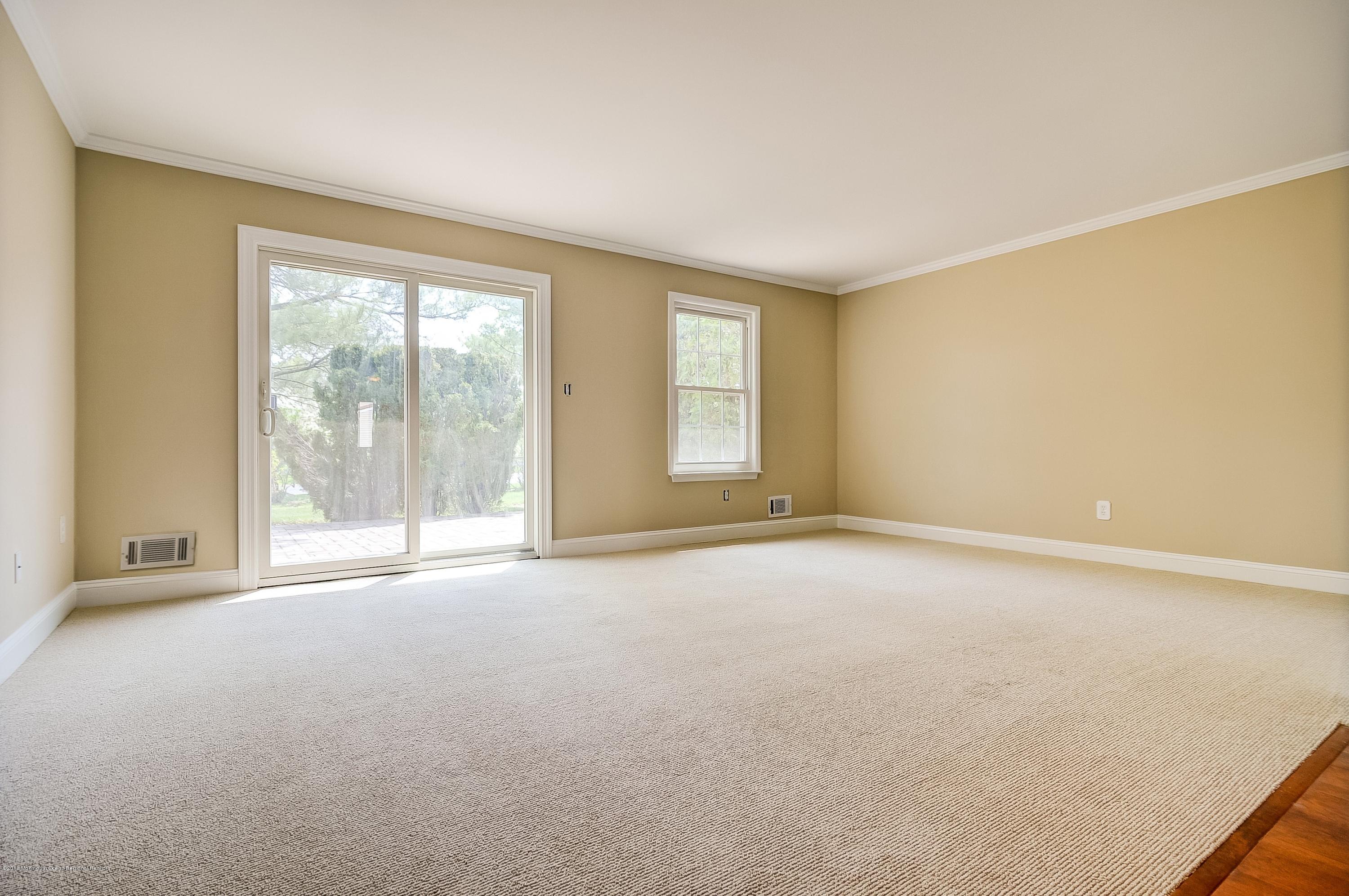 41 Apple Drive Spring Lake Heights, NJ 07762 - Photo 6 of 32 an empty room with a fireplace and large windows