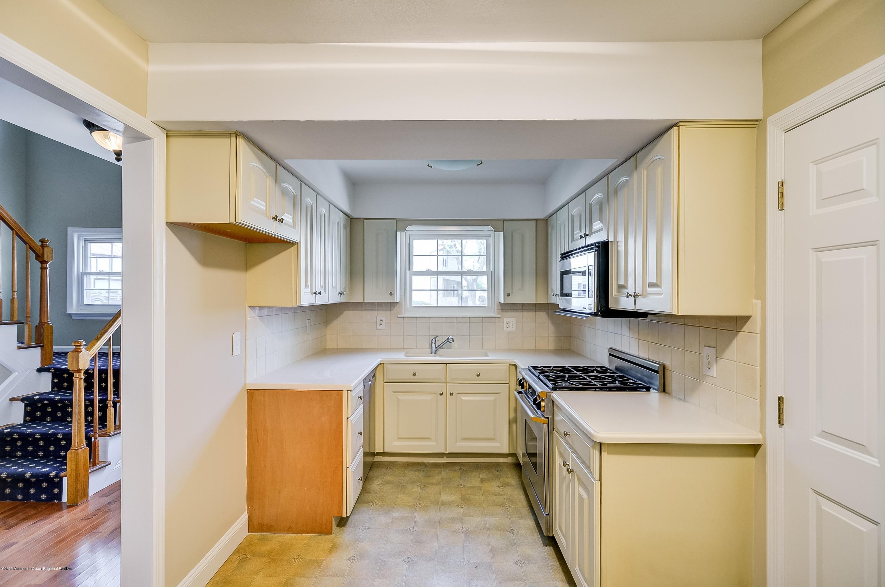 41 Apple Drive Spring Lake Heights, NJ 07762 - Photo 8 of 32 a kitchen with stainless steel appliances a sink a stove a refrigerator cabinets and a window