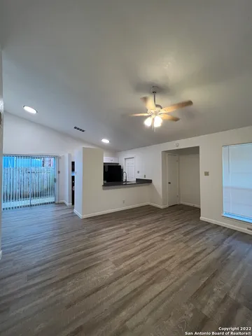 a view of a livingroom with a ceiling fan wooden floor and a ceiling fan