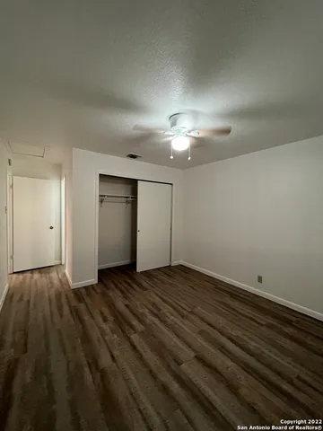 a view of an empty room with a chandelier fan