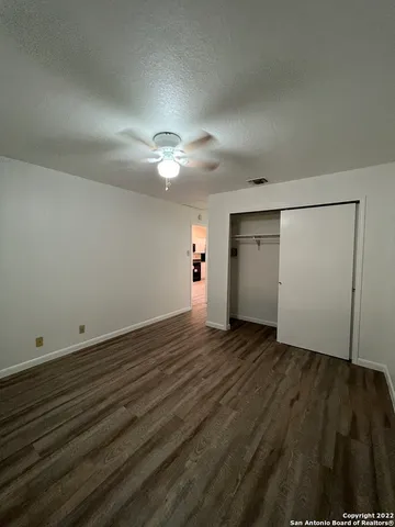 an empty room with wooden floor and window