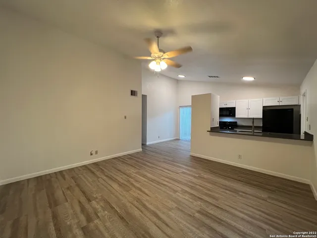 a view of kitchen with wooden floor and a refrigerator