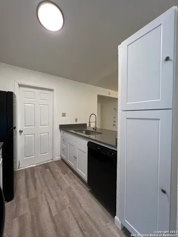 a kitchen with a refrigerator sink and cabinets