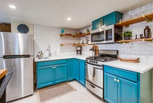 a kitchen with stainless steel appliances granite countertop a stove a refrigerator and a sink