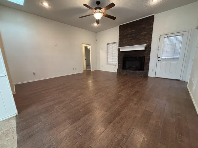 an empty room with windows and fireplace