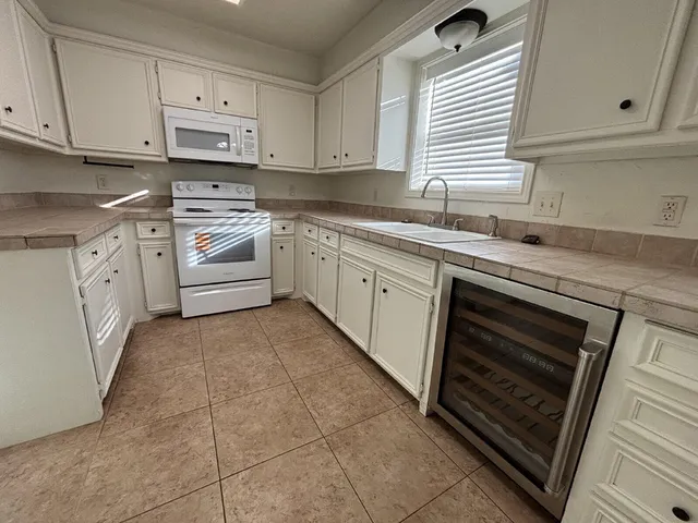 a kitchen with cabinets appliances and a window