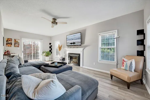 a living room with furniture fireplace and a large window