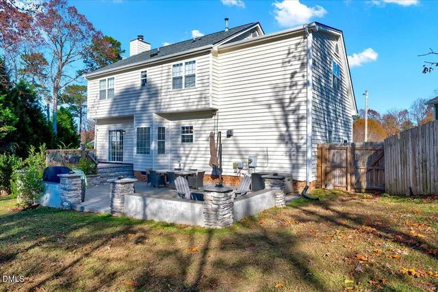 a view of a house with backyard and sitting area