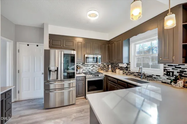 a kitchen with stainless steel appliances granite countertop a sink stove and refrigerator