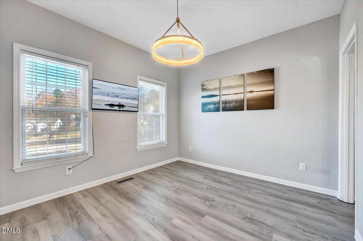 6900 Whittlesea Place Raleigh, NC 27616 - Photo 7 of 39 a view of empty room with wooden floor and fan