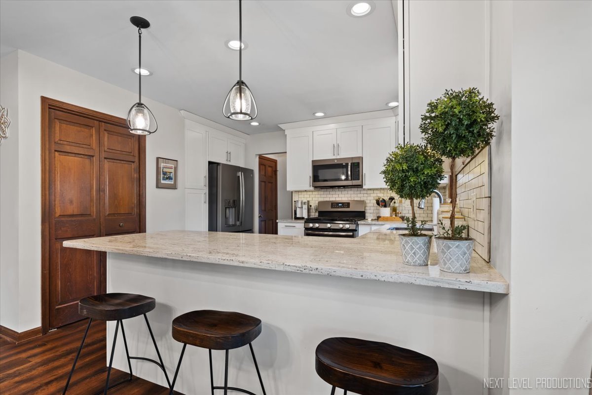 78 South Stauffer Drive Naperville, IL 60540 - Photo 11 of 31 a kitchen with stainless steel appliances a table chairs refrigerator and microwave