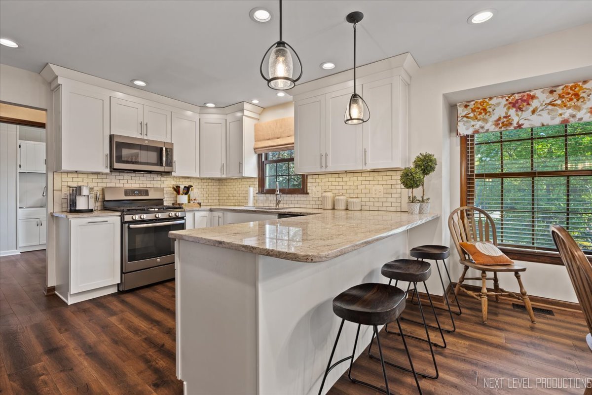 78 South Stauffer Drive Naperville, IL 60540 - Photo 9 of 31 a kitchen with stainless steel appliances granite countertop a stove top oven a sink a dining table and chairs with wooden floor