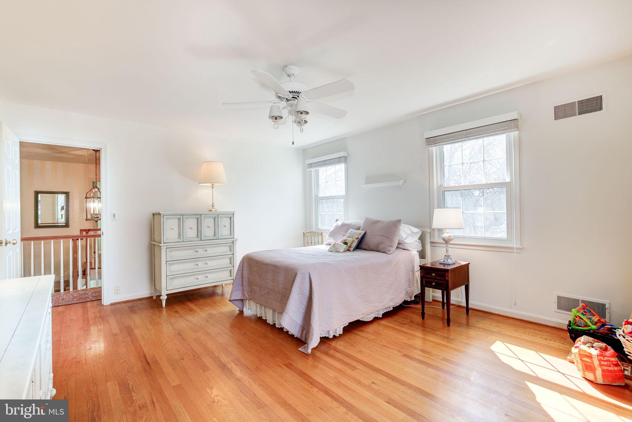 14709 Spring Meadows Drive Darnestown, MD 20874 - Photo 18 of 40 a spacious bedroom with a bed a chandelier and windows