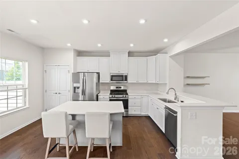 a kitchen with a sink a refrigerator and white cabinets