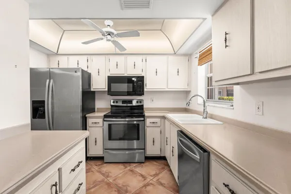 a kitchen with stainless steel appliances a stove sink microwave and refrigerator