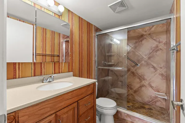 a bathroom with a granite countertop sink toilet and shower