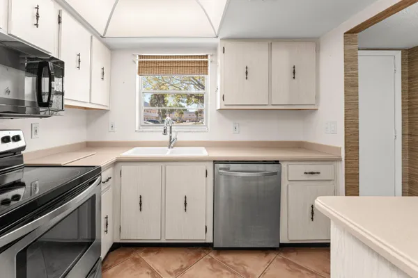 a kitchen with white cabinets and white appliances