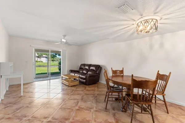 a dining room with furniture and a floor to ceiling window