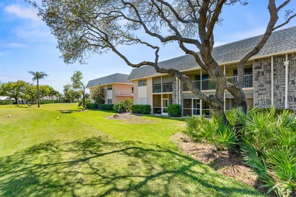 a view of a house with a big yard and large trees