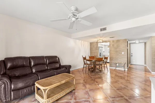 a living room with furniture and a view of kitchen