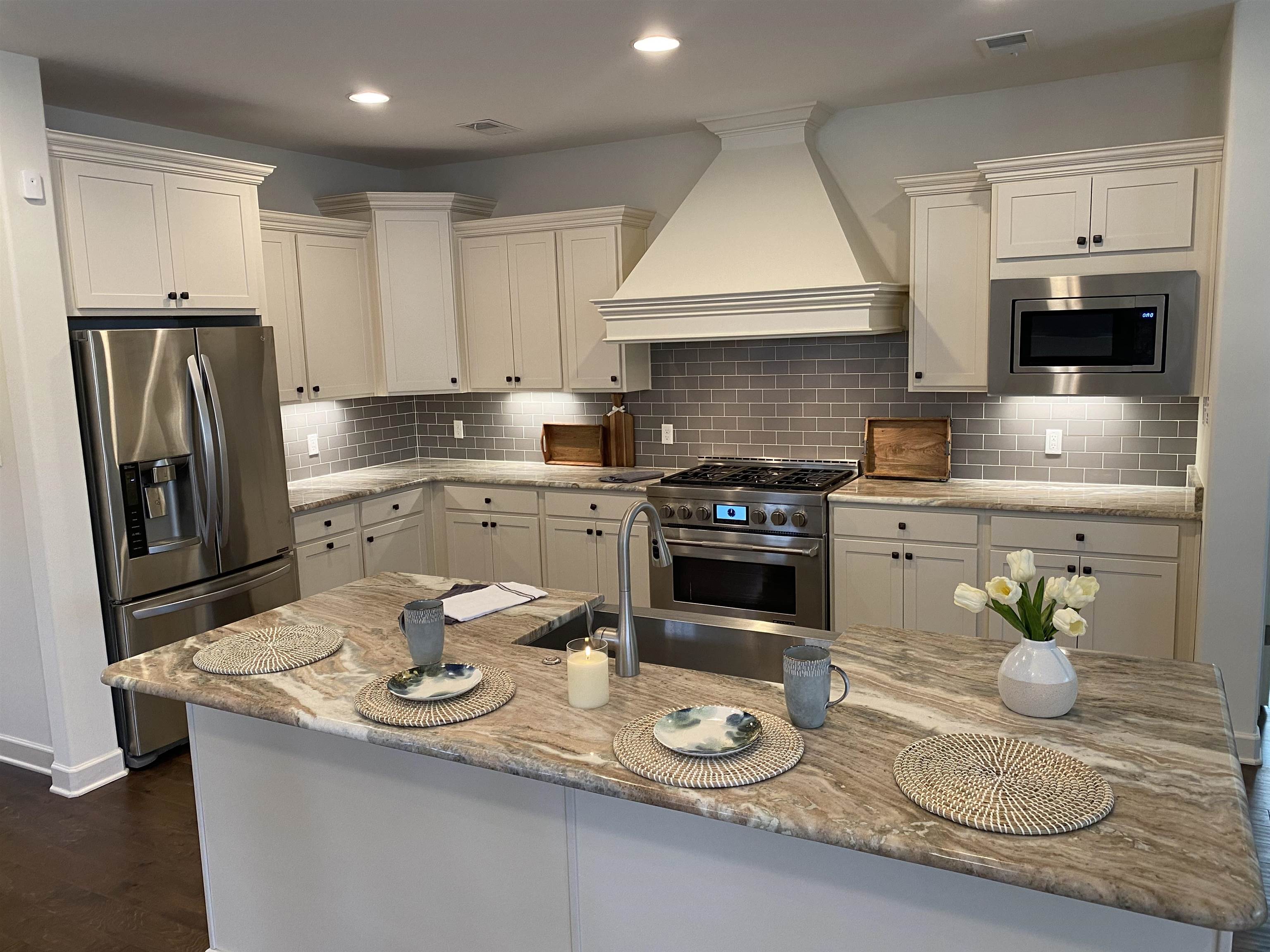 4713 Emmas Circle West Collierville, TN 38017 - Photo 6 of 25 a kitchen with a sink a stove and chairs