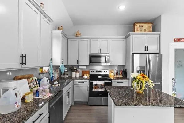 a kitchen with stainless steel appliances granite countertop a sink stove and refrigerator