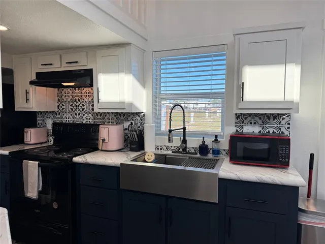 a kitchen with a sink stove and microwave