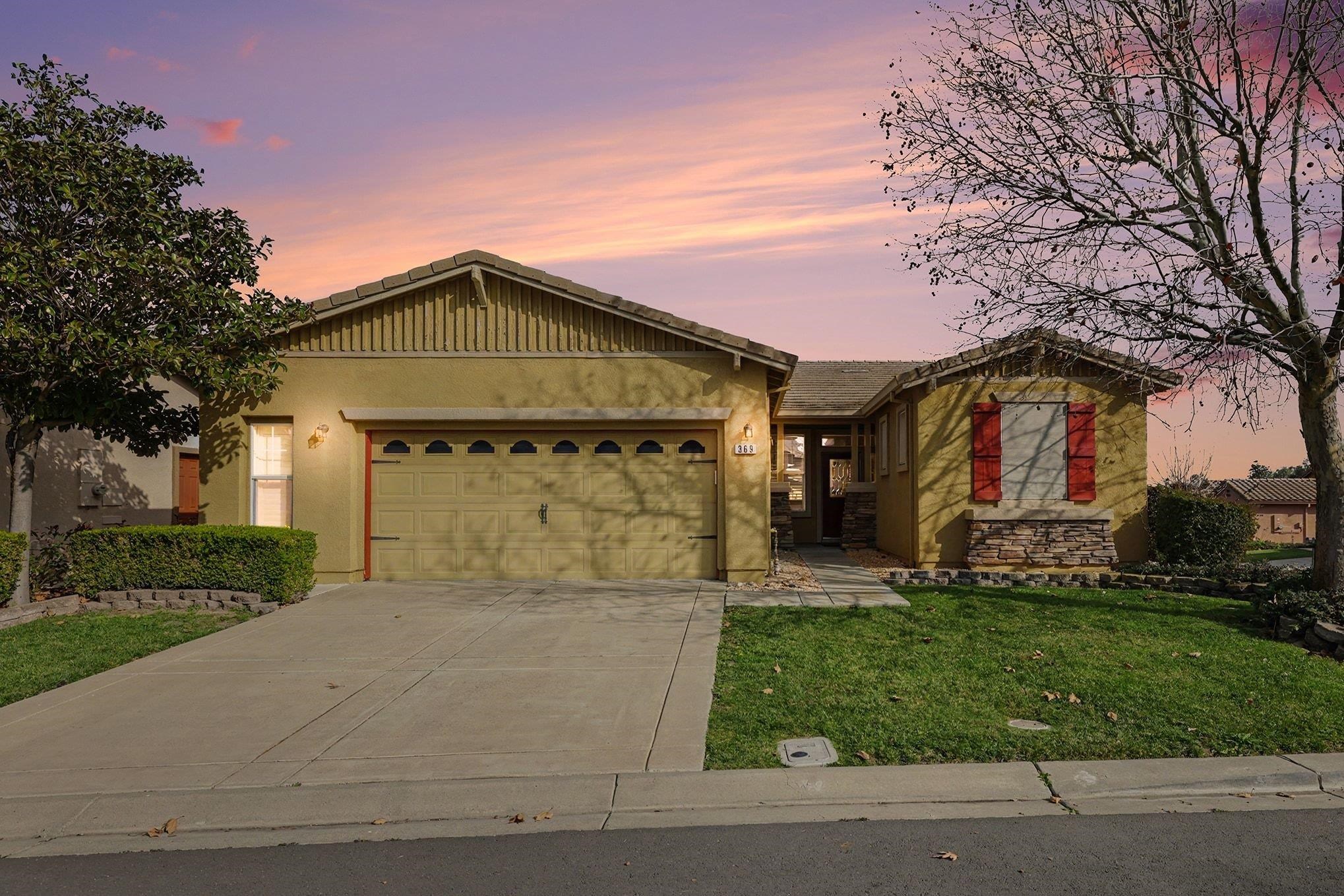 a front view of a house with a yard and garage