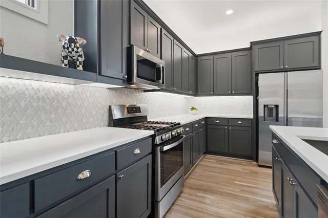 a kitchen with stainless steel appliances a sink dishwasher stove and refrigerator