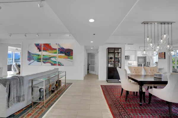 a dining room with furniture a rug and a chandelier