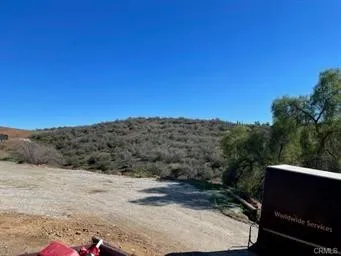 a view of a dry yard with trees