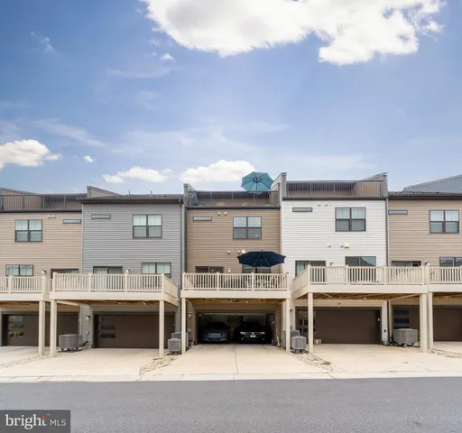 a front view of a brick house with a yard and plants