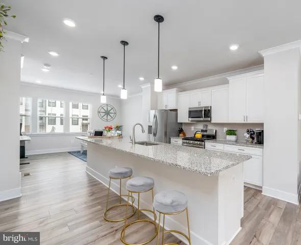 a kitchen with stainless steel appliances granite countertop a stove a sink and a white cabinets