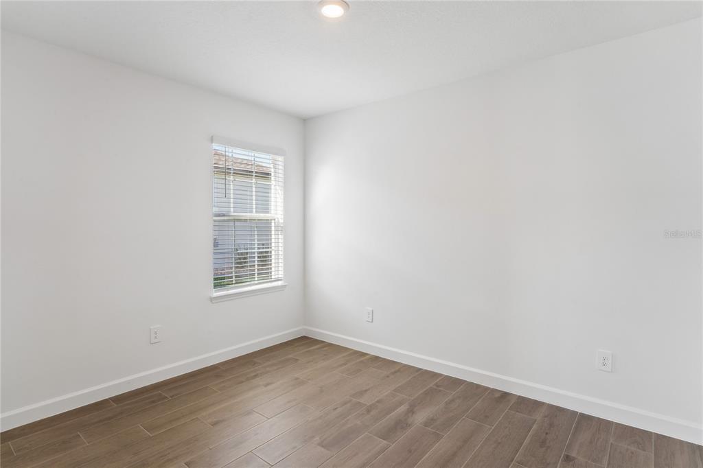 6692 Homebound Way New Port Richey, FL 34653 - Photo 27 of 47 a view of an empty room with wooden floor and a window