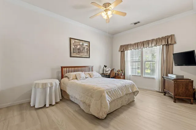 a bedroom with a large bed and a chandelier